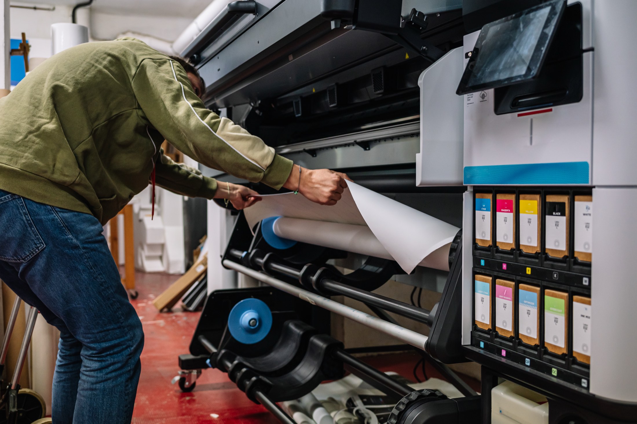 Operario cargando un rollo de material en una impresora de gran formato